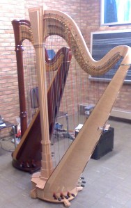 Two orchestral harps standing side by side